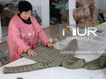 Workers make down jackets at a workshop of a garment manufacturer in Hehe town, Yangxin county, Binzhou city, East China's Shandong province...