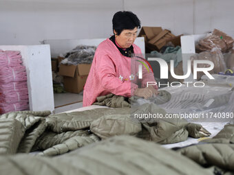 Workers make down jackets at a workshop of a garment manufacturer in Hehe town, Yangxin county, Binzhou city, East China's Shandong province...