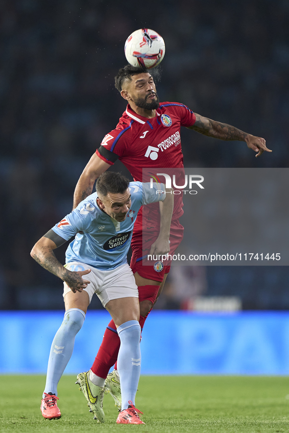 Omar Alderete of Getafe CF competes for the ball with Iago Aspas of RC Celta de Vigo during the La Liga EA Sports match between RC Celta de...