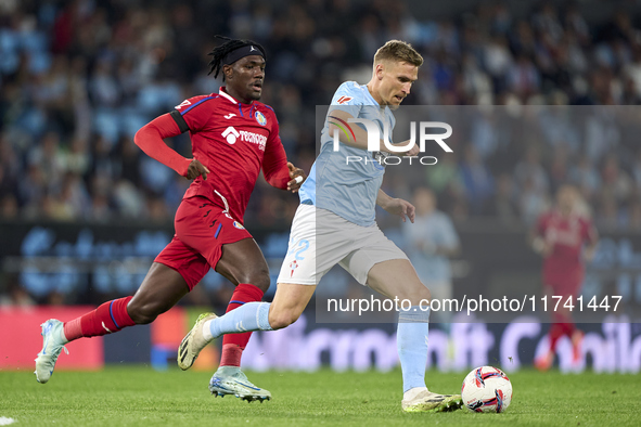 Carl Starfelt of RC Celta de Vigo is challenged by Christantus Uche of Getafe CF during the La Liga EA Sports match between RC Celta de Vigo...