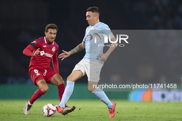 Iago Aspas of RC Celta de Vigo is challenged by Luis Milla of Getafe CF during the La Liga EA Sports match between RC Celta de Vigo and Geta...