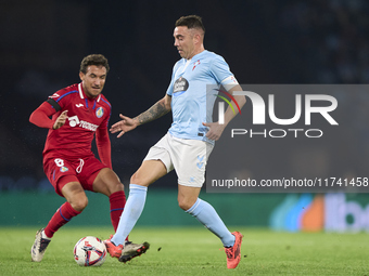 Iago Aspas of RC Celta de Vigo is challenged by Luis Milla of Getafe CF during the La Liga EA Sports match between RC Celta de Vigo and Geta...