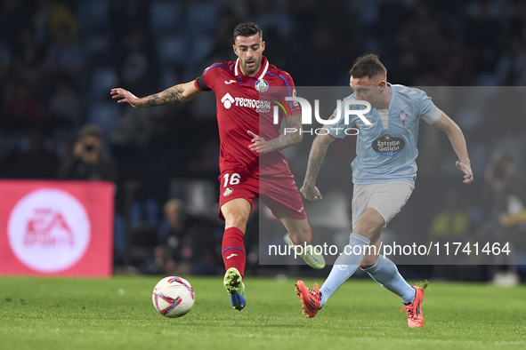 Iago Aspas of RC Celta de Vigo is challenged by Diego Rico of Getafe CF during the La Liga EA Sports match between RC Celta de Vigo and Geta...