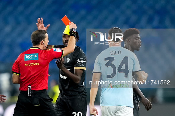 Referee Nicola Ayroldi shows a red card to Michel Ndary Adopo of Cagliari Calcio during the Serie A Enilive match between SS Lazio and Cagli...