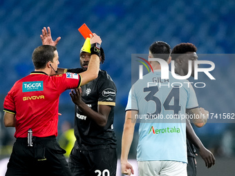 Referee Nicola Ayroldi shows a red card to Michel Ndary Adopo of Cagliari Calcio during the Serie A Enilive match between SS Lazio and Cagli...