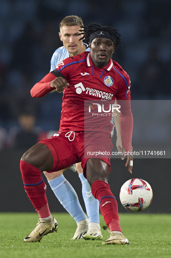 Christantus Uche of Getafe CF is challenged by Carl Starfelt of RC Celta de Vigo during the La Liga EA Sports match between RC Celta de Vigo...