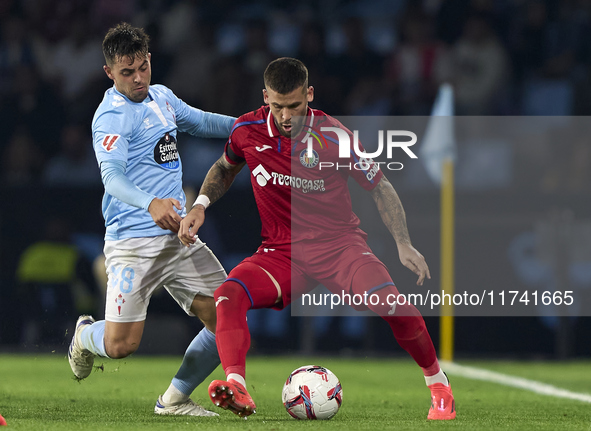 Fran Beltran of RC Celta de Vigo competes for the ball with Carles Perez of Getafe CF during the La Liga EA Sports match between RC Celta de...