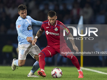 Fran Beltran of RC Celta de Vigo competes for the ball with Carles Perez of Getafe CF during the La Liga EA Sports match between RC Celta de...