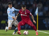 Fran Beltran of RC Celta de Vigo competes for the ball with Carles Perez of Getafe CF during the La Liga EA Sports match between RC Celta de...