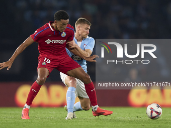 Carl Starfelt of RC Celta de Vigo competes for the ball with Alvaro Rodriguez of Getafe CF during the La Liga EA Sports match between RC Cel...