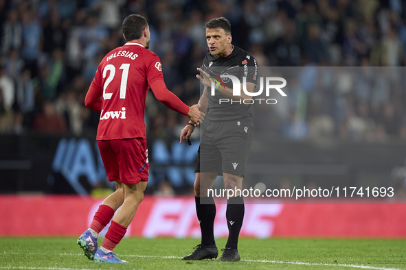 Referee Jesus Gil Manzano and Juan Iglesias of Getafe CF discuss during the La Liga EA Sports match between RC Celta de Vigo and Getafe CF a...