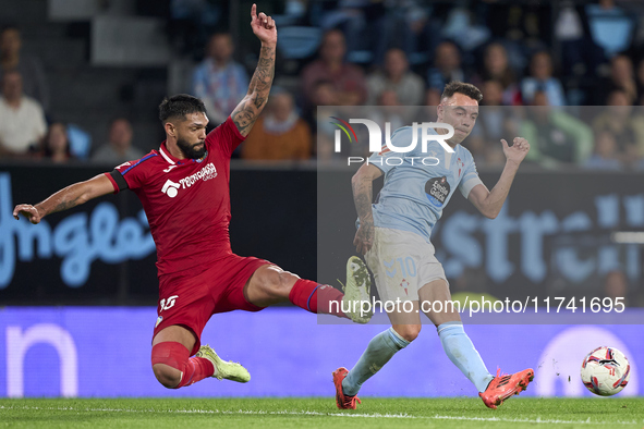 Omar Alderete of Getafe CF competes for the ball with Iago Aspas of RC Celta de Vigo during the La Liga EA Sports match between RC Celta de...