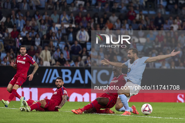 Allan Nyom of Getafe CF competes for the ball with Borja Iglesias of RC Celta de Vigo during the La Liga EA Sports match between RC Celta de...