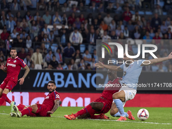 Allan Nyom of Getafe CF competes for the ball with Borja Iglesias of RC Celta de Vigo during the La Liga EA Sports match between RC Celta de...