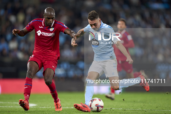 Allan Nyom of Getafe CF competes for the ball with Iago Aspas of RC Celta de Vigo during the La Liga EA Sports match between RC Celta de Vig...