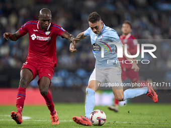 Allan Nyom of Getafe CF competes for the ball with Iago Aspas of RC Celta de Vigo during the La Liga EA Sports match between RC Celta de Vig...