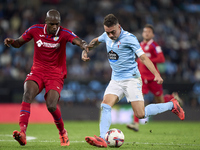 Allan Nyom of Getafe CF competes for the ball with Iago Aspas of RC Celta de Vigo during the La Liga EA Sports match between RC Celta de Vig...