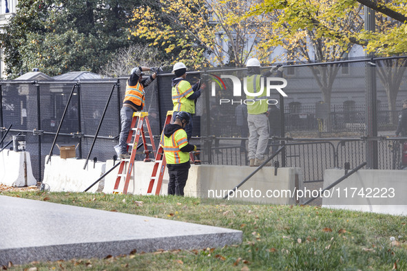 Workers erect security fences surrounding the construction site for the 2025 Presidential Inaugural Parade Reviewing Stand in Lafayette Squa...