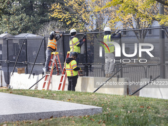 Workers erect security fences surrounding the construction site for the 2025 Presidential Inaugural Parade Reviewing Stand in Lafayette Squa...