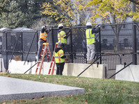 Workers erect security fences surrounding the construction site for the 2025 Presidential Inaugural Parade Reviewing Stand in Lafayette Squa...