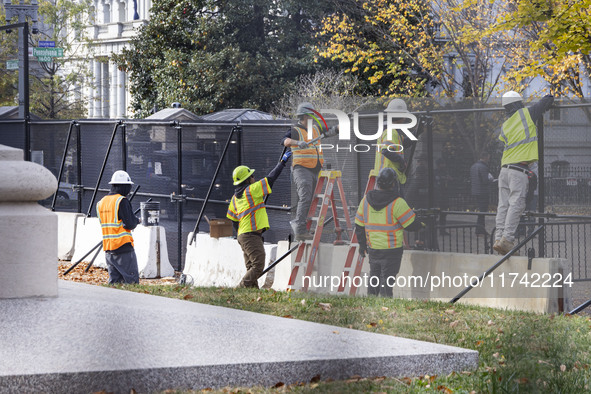 Workers erect security fences surrounding the construction site for the 2025 Presidential Inaugural Parade Reviewing Stand in Lafayette Squa...