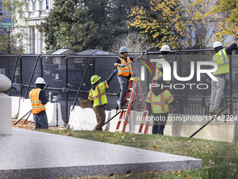 Workers erect security fences surrounding the construction site for the 2025 Presidential Inaugural Parade Reviewing Stand in Lafayette Squa...