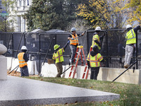 Workers erect security fences surrounding the construction site for the 2025 Presidential Inaugural Parade Reviewing Stand in Lafayette Squa...