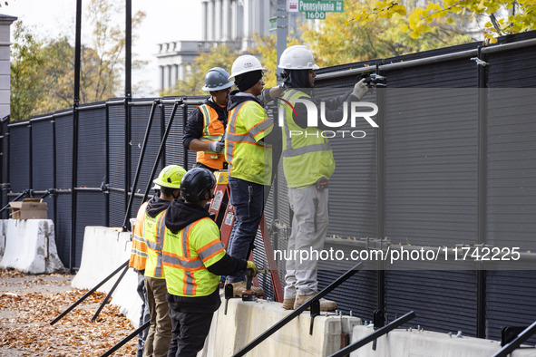 Workers erect security fences surrounding the construction site for the 2025 Presidential Inaugural Parade Reviewing Stand in Lafayette Squa...