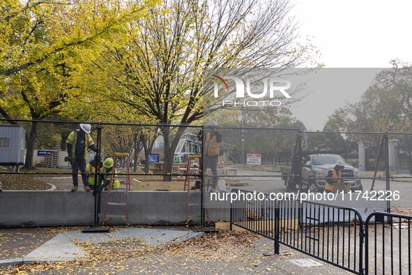 Workers erect security fences surrounding the construction site for the 2025 Presidential Inaugural Parade Reviewing Stand in Lafayette Squa...