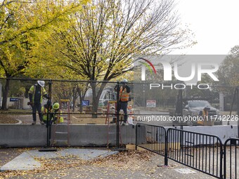 Workers erect security fences surrounding the construction site for the 2025 Presidential Inaugural Parade Reviewing Stand in Lafayette Squa...