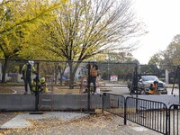 Workers erect security fences surrounding the construction site for the 2025 Presidential Inaugural Parade Reviewing Stand in Lafayette Squa...