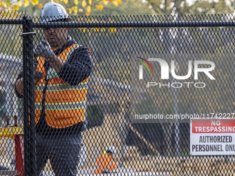 Workers erect security fences surrounding the construction site for the 2025 Presidential Inaugural Parade Reviewing Stand in Lafayette Squa...