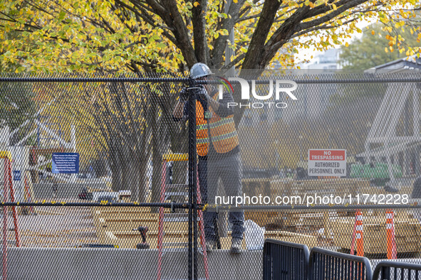 Workers erect security fences surrounding the construction site for the 2025 Presidential Inaugural Parade Reviewing Stand in Lafayette Squa...