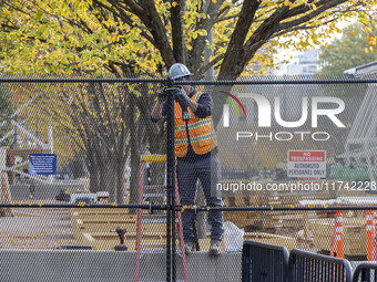 Workers erect security fences surrounding the construction site for the 2025 Presidential Inaugural Parade Reviewing Stand in Lafayette Squa...