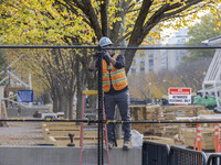 Workers erect security fences surrounding the construction site for the 2025 Presidential Inaugural Parade Reviewing Stand in Lafayette Squa...