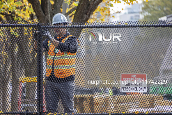 Workers erect security fences surrounding the construction site for the 2025 Presidential Inaugural Parade Reviewing Stand in Lafayette Squa...