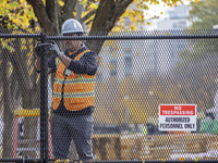 Workers erect security fences surrounding the construction site for the 2025 Presidential Inaugural Parade Reviewing Stand in Lafayette Squa...