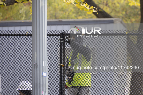 Workers erect security fences surrounding the construction site for the 2025 Presidential Inaugural Parade Reviewing Stand in Lafayette Squa...