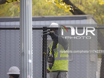 Workers erect security fences surrounding the construction site for the 2025 Presidential Inaugural Parade Reviewing Stand in Lafayette Squa...