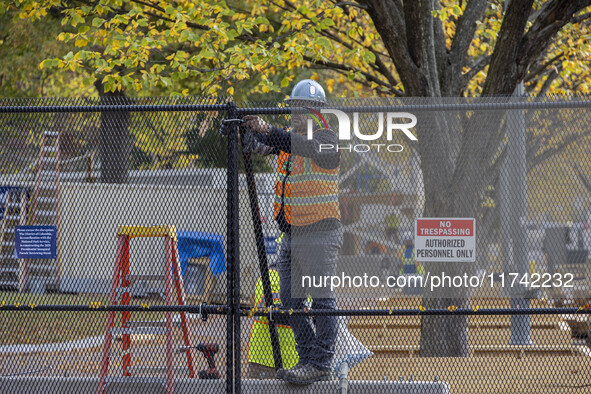 Workers erect security fences surrounding the construction site for the 2025 Presidential Inaugural Parade Reviewing Stand in Lafayette Squa...