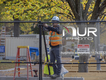 Workers erect security fences surrounding the construction site for the 2025 Presidential Inaugural Parade Reviewing Stand in Lafayette Squa...