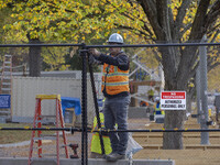 Workers erect security fences surrounding the construction site for the 2025 Presidential Inaugural Parade Reviewing Stand in Lafayette Squa...