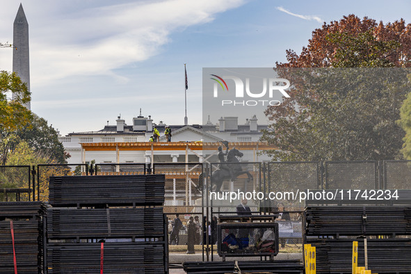 Workers erect security fences surrounding the construction site for the 2025 Presidential Inaugural Parade Reviewing Stand in Lafayette Squa...