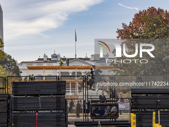 Workers erect security fences surrounding the construction site for the 2025 Presidential Inaugural Parade Reviewing Stand in Lafayette Squa...