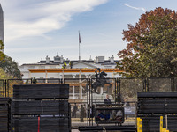 Workers erect security fences surrounding the construction site for the 2025 Presidential Inaugural Parade Reviewing Stand in Lafayette Squa...