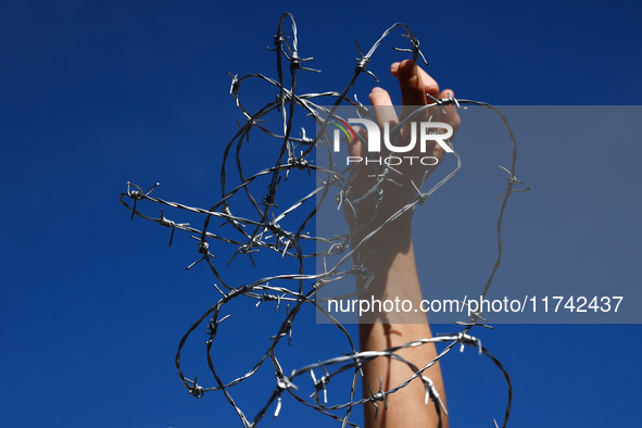 A person holds barbed wire while attending a demonstration against the Polish government's plans to suspend the right to asylum for refugees...