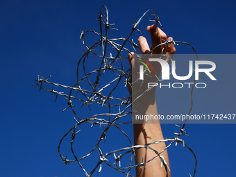 A person holds barbed wire while attending a demonstration against the Polish government's plans to suspend the right to asylum for refugees...