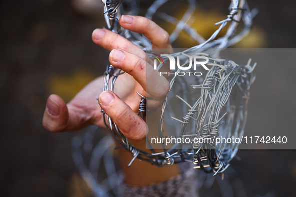 A person holds barbed wire while attending a demonstration against the Polish government's plans to suspend the right to asylum for refugees...