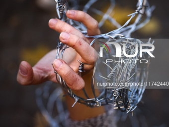 A person holds barbed wire while attending a demonstration against the Polish government's plans to suspend the right to asylum for refugees...