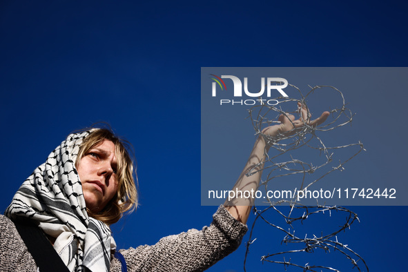 A woman holds barbed wire while attending a demonstration against the Polish government's plans to suspend the right to asylum for refugees...